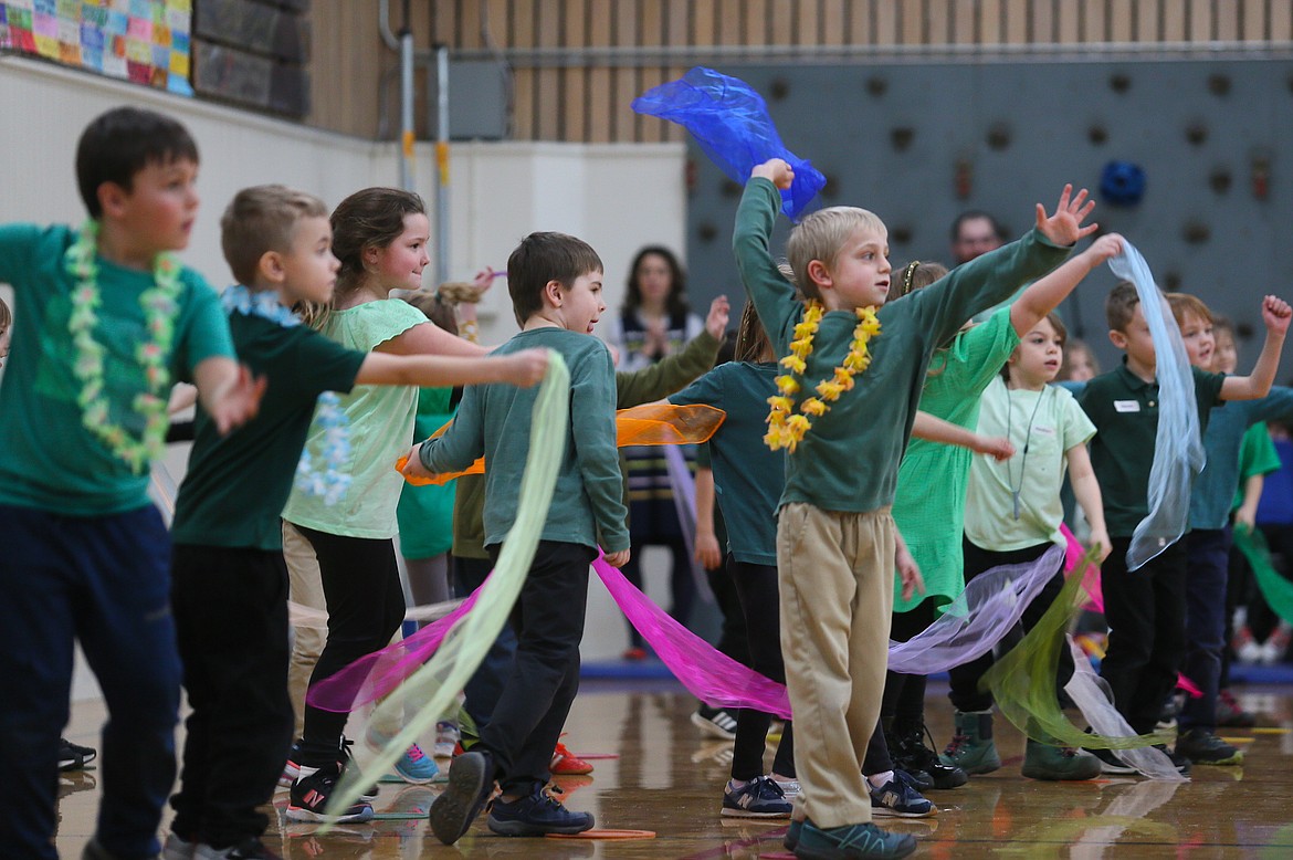 Sorensen Magnet School student Parker Tollett, wearing a yellow lei, is feeling the music Friday as he participates in a traditional scarf dance with his classmates.