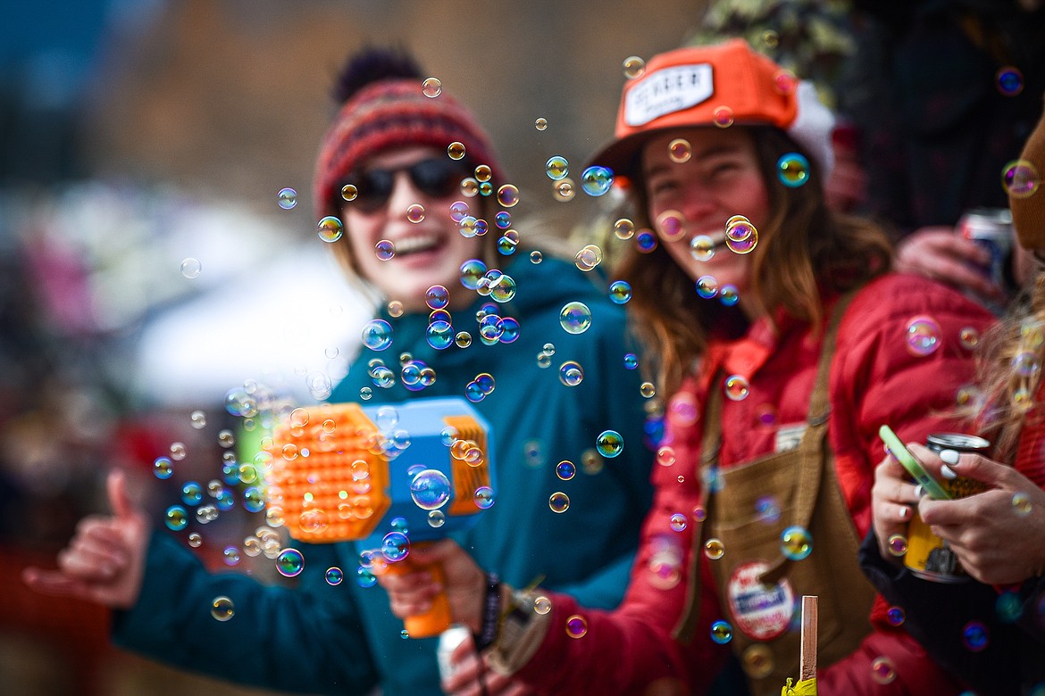 An attendee uses a  bubble gun at the finish line at the Barstool Ski Races at Cabin Fever Days in Martin City on Saturday, Feb. 10. (Casey Kreider/Daily Inter Lake)