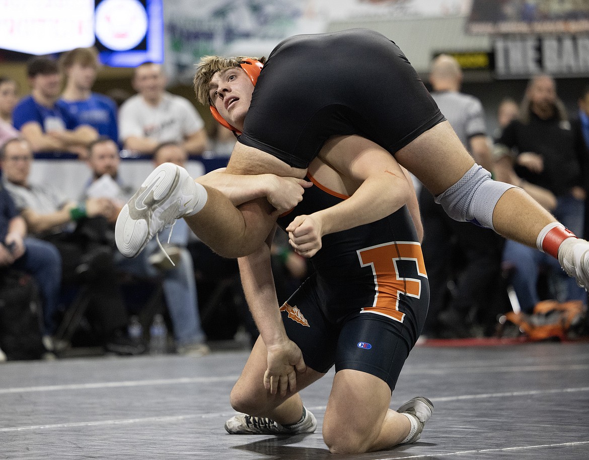 FLATHEAD HEAVYWEIGHT Sawyer Troupe carries Bozeman’s Hudson Weins during their championship match Saturday. Troupe capped an unbeaten season with a pin, winning his first state title. (Amy Lynn Nelson, Billings Gazette)