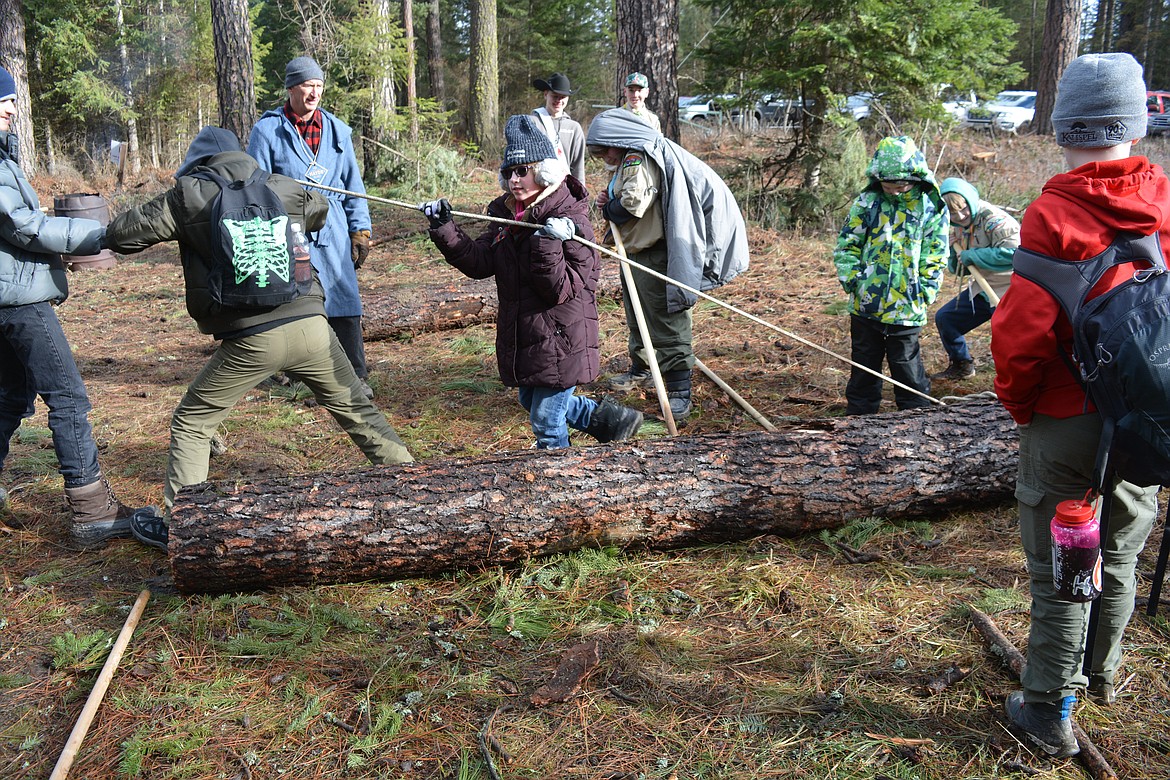 The log roll station proved to be a tricky one for Mason Wilke, Emily Lehman, and Oliver Doughty. The troop tried to haul the log out of the starting area with a rope, but weren't able to accomplish the goal in 20 minutes. Afterwards, they strategized with the adults to strengthen their communication as a team and listen to each other's suggestions.