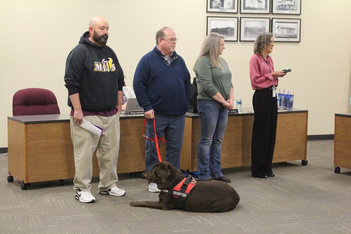 Moses Lake School District counselors, from left, Enrique Tarver, Chris Mason and Mari Cardwell are introduced during the Moses Lake School Board meeting by Assistant Superintendent Carol Lewis, right. Brodi, the therapy dog that accompanies Mason around Columbia Middle School, is in the foreground.