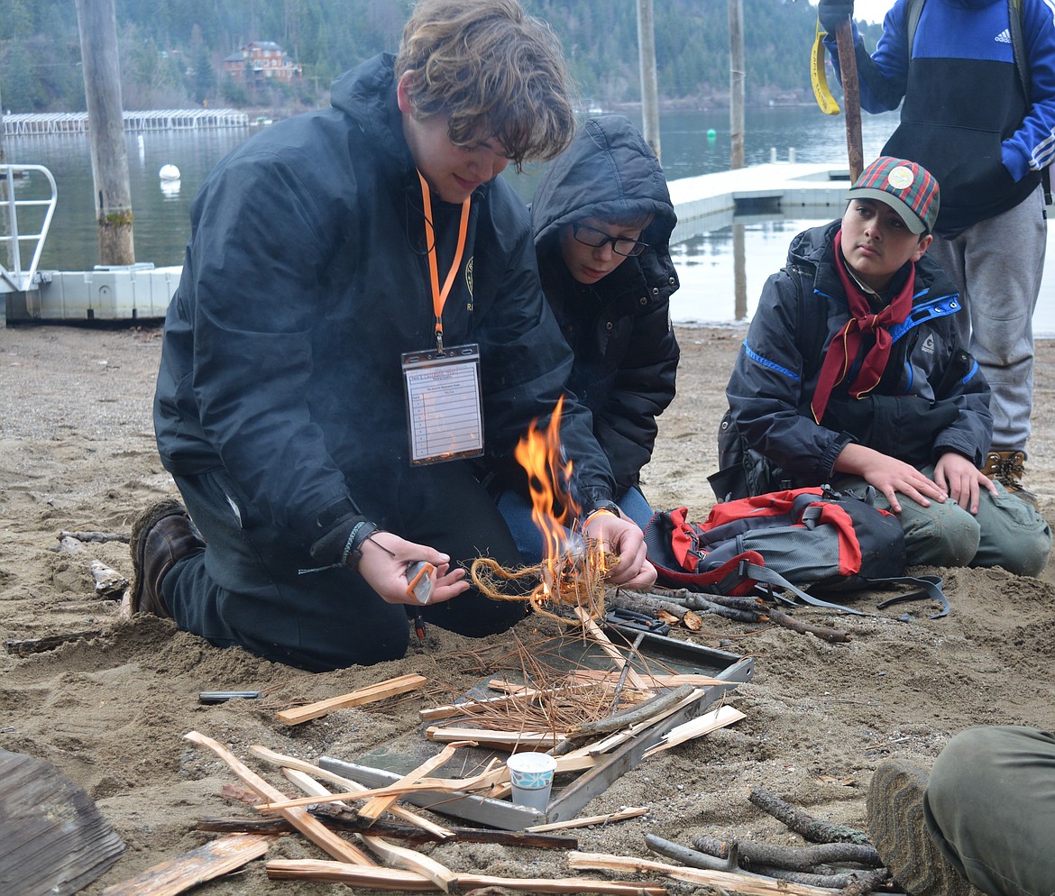 Riley Thompson, Cameron Elwess and Andre Bond watch as the kindling begins to catch fire.