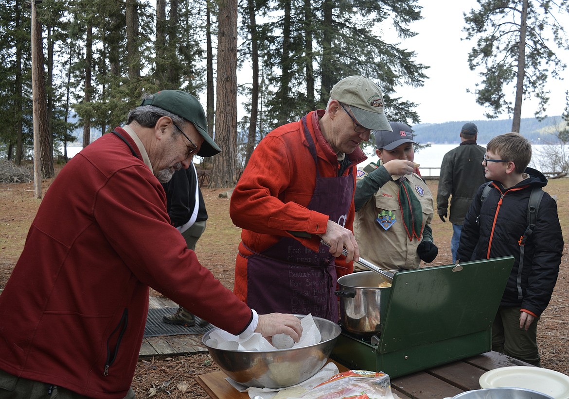 Dale Keiser and Cliff Garrison make "sugar crustos" for hungry scouts taking a break between challenges. The food also helped serve as an ice breaker for the recruiting drive for the order of the arrow. 
Scouts Ryker Smithson and Elias Owens prepare to enjoy the fried dough coated in cinnamon and sugar.