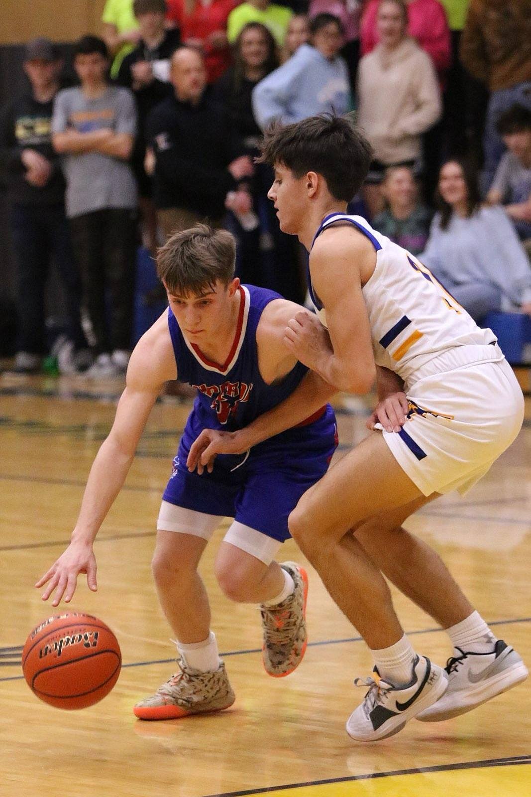 Superior freshman Gannon Quinland (blue) is guarded by Thompson Falls junior Sam Burgess during their game Saturday night in T Falls.  (Photo by Byron Quinlan)