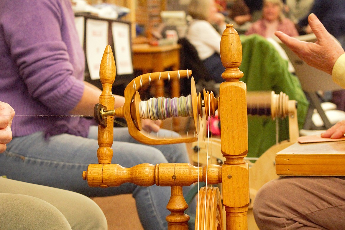 Linda Corson spins yarn on her spinning wheel.