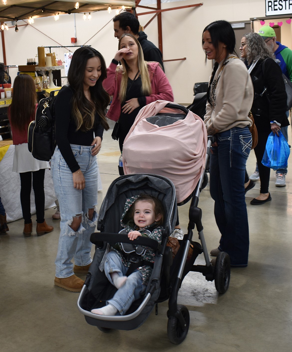 From left: Rheese Meza, Brianna Rios and Whitney Smith catch up and share a laugh at the Valentine’s Market Saturday, while 1-year-old Blythe Dagorret waits patiently in her stroller.