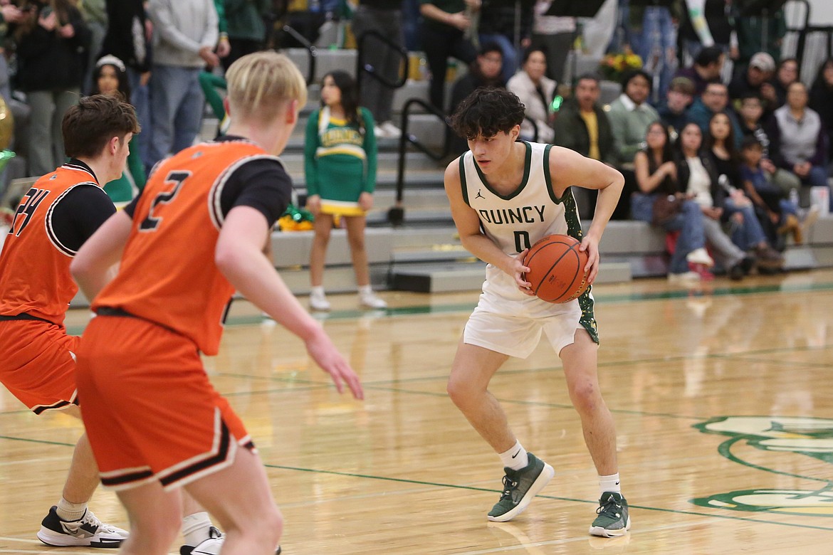 Quincy senior Dom Trevino, in white, keeps his eyes on a Cashmere defender during a Jan. 25 game.