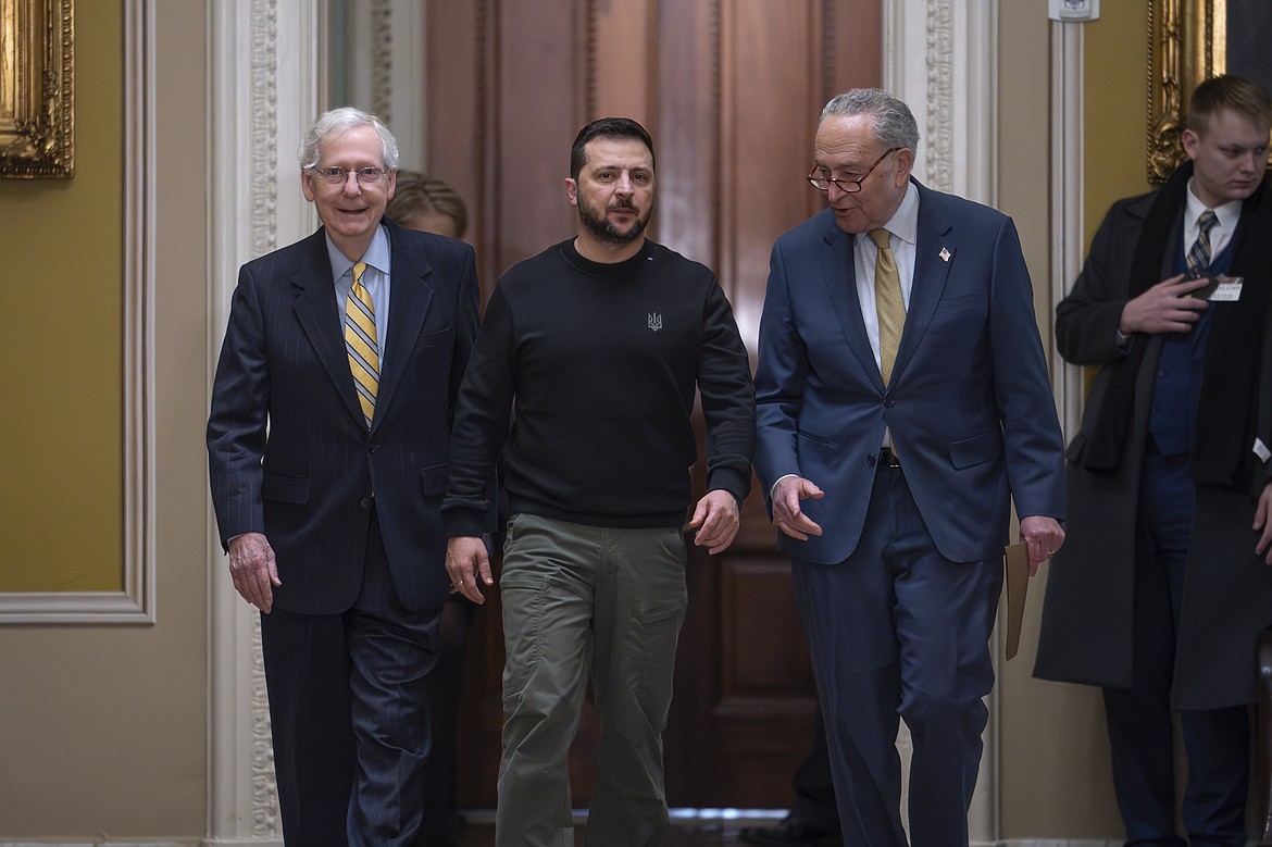 Ukrainian President Volodymyr Zelenskyy, center, is escorted by Senate Minority Leader Mitch McConnell, R-Ky., left, and Senate Majority Leader Chuck Schumer, D-N.Y., as he comes to the Capitol in Washington to issue a plea for Congress to break its deadlock and approve continued wartime funding for Ukraine, Dec. 12, 2023. Two months later, that aid request had still not been met but Schumer and McConnell are keeping the Senate in session on Super Bowl weekend to force funding for Ukraine and Israel. (AP Photo/J. Scott Applewhite, File)