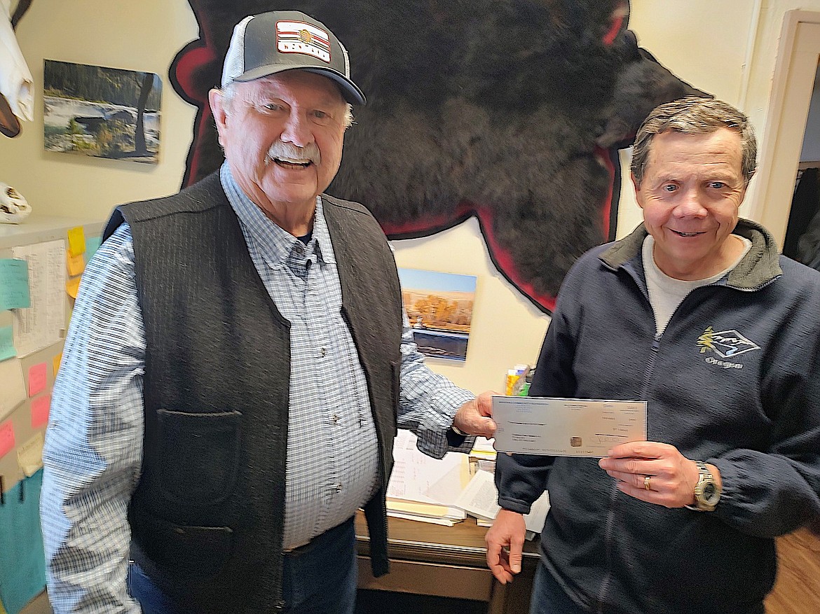 Lincoln County Community Foundation's Bernie Cassidy presents a $1,000 check to Jim Dunnigan with Kootenai River Trailworks. The grant is to assist in the development of a river trail system. (Courtesy photo)