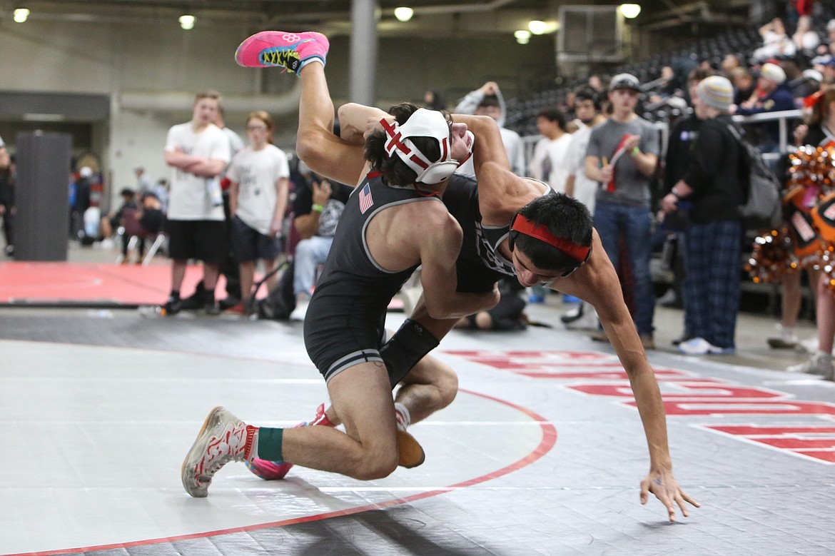 Othello senior Isaac Campos, left, and sophomore Daniel Gonzalez, right, wrestle against one another at the Central Washington Athletic Conference district tournament in Yakima. Both wrestlers are heading to the Mat Classic in Tacoma.