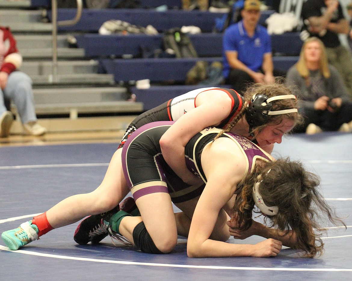 Sandpoint's Mackenzee Donenfeld takes the back of Kellogg's Sophia McLain in the 100-pound district championship match. Donenfeld eventually clinched the district title with a third period pin.