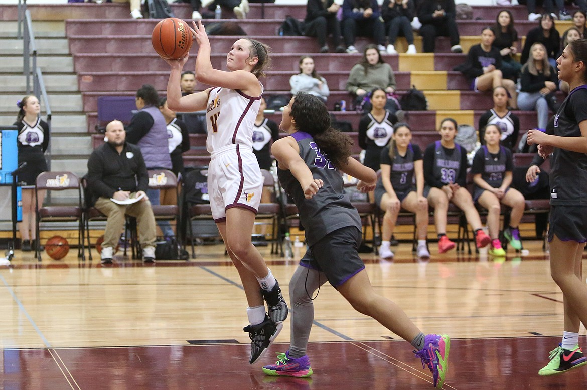 Moses Lake senior Lexi Cox, in white, attempts a layup during a Dec. 12 game against Pasco.