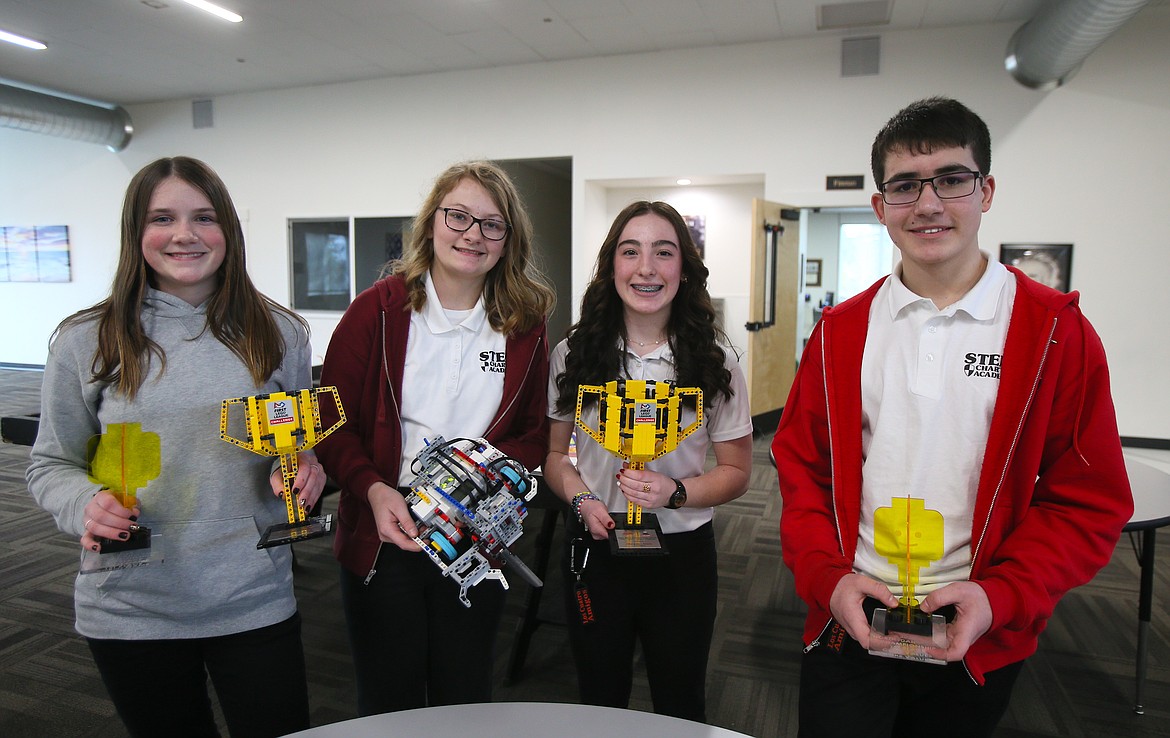 From left, North Idaho STEM Charter Academy eighth graders Kaylee Barnhart, Amelia Freeman, Reagan Smith and Emmett Hernandez show off recent FIRST Lego League trophies at their school Wednesday. The young robotics enthusiasts will compete against teams from around the world at the FIRST Championship in April in Houston.