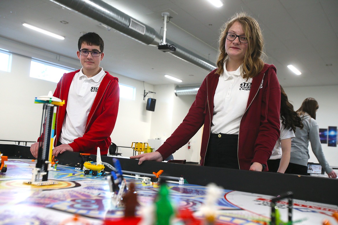 Emmett Hernandez and Amelia Freeman, North Idaho STEM Charter Academy eighth graders, stand with their FIRST Lego League robotics table Wednesday as they show how they have programmed their robots to complete certain tasks.