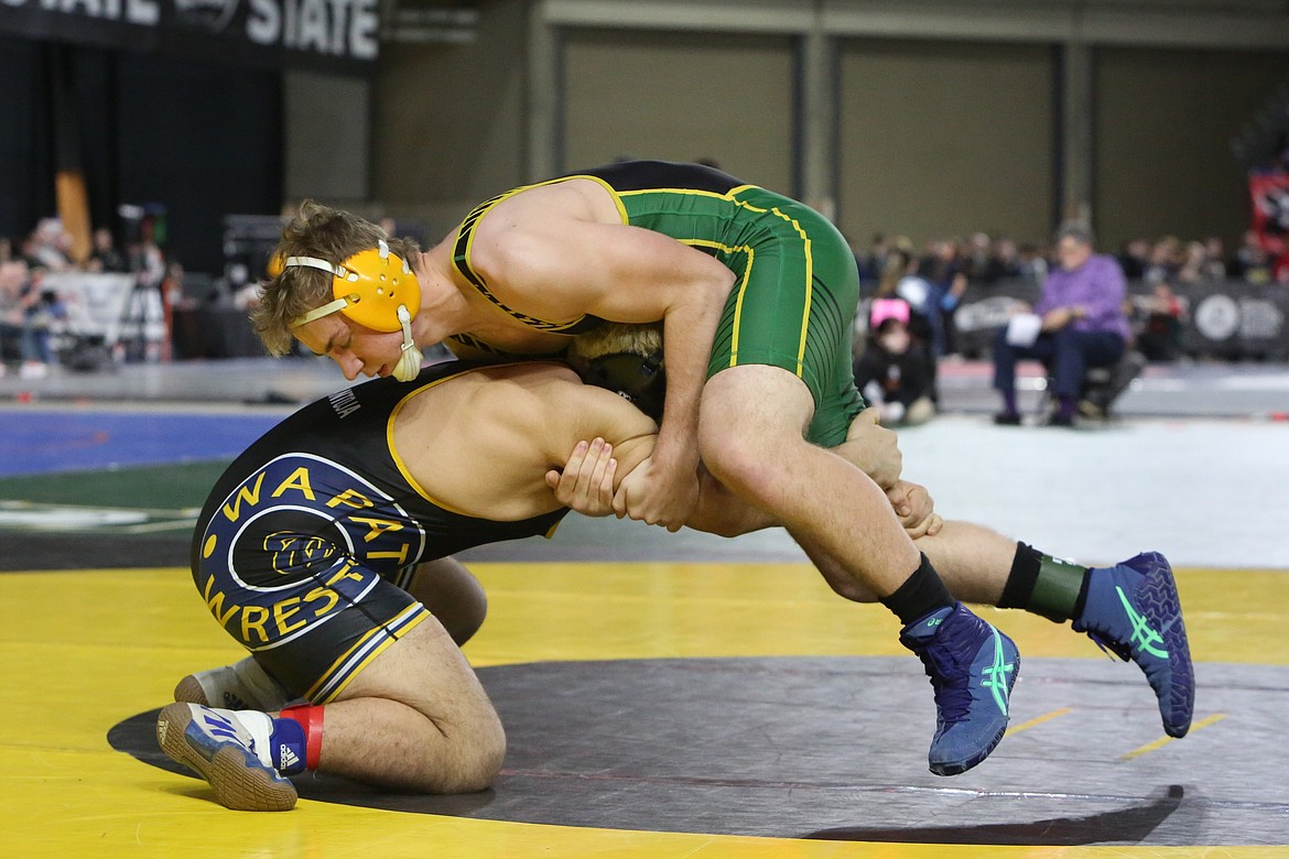 Quincy senior Kaleb Klempel, in green, wins a match at the Mat Classic against Wapato’s Alexis Paredes.