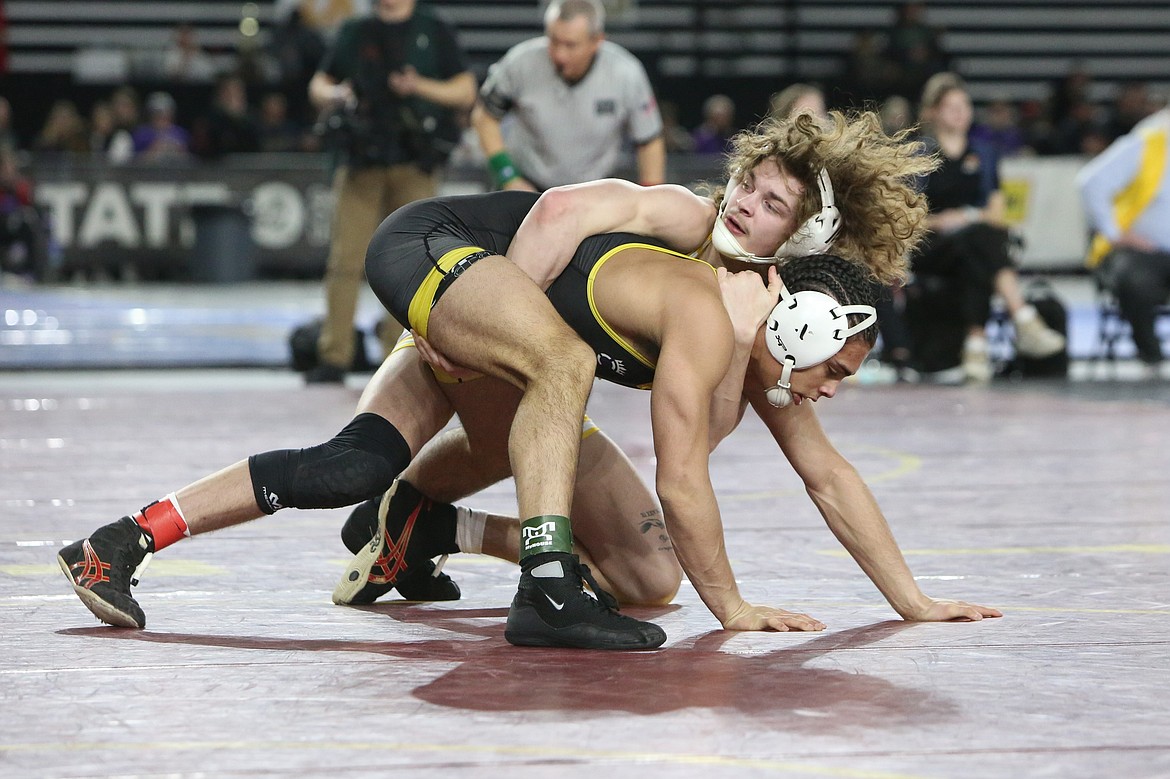 Moses Lake senior Dayton Regan, background, takes a look at the clock during his semifinal match at the 4A Mat Classic in Tacoma. Regan placed second in the 4A 150-pound class.