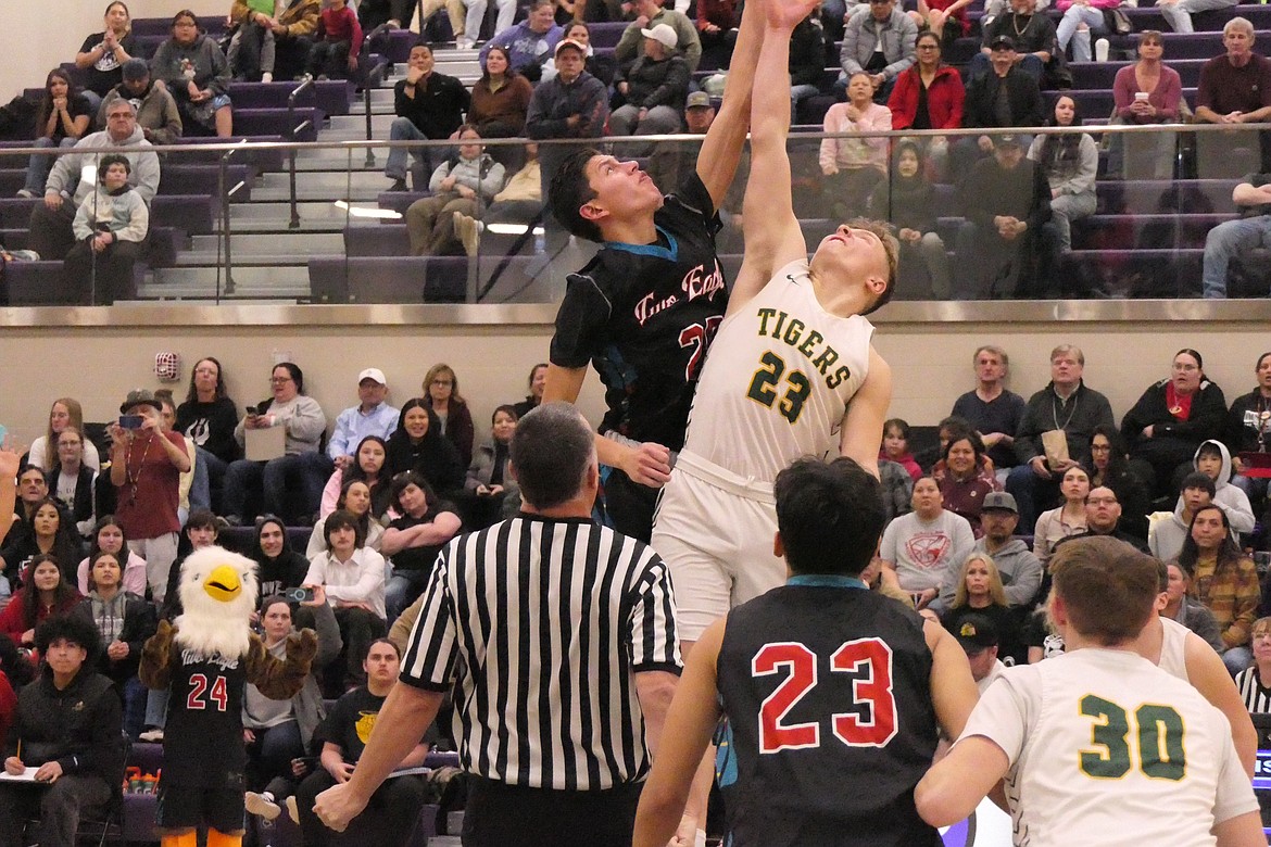 Two Eagle River forward Jabez Madplume (black) and St. Regis senior forward John Pruitt go for the opening tip-off during their 14C championship game Saturday night in Polson. (Chuck Bandel/MI-VP)