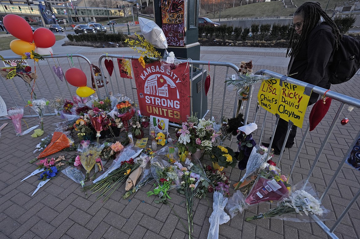 A person views a memorial dedicated to the victims of last week's mass shooting in front of Union Station, Sunday, Feb. 18, 2024, in Kansas City, Mo. Authorities say two juveniles have been charged with crimes connected to the shooting at the Kansas City Chiefs’ Super Bowl rally. (AP Photo/Charlie Riedel)