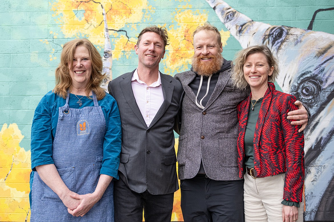 Uptown Hearth’s original owner Terri Feury and new partners Matthew Bussard, Chas Brandt and Hillary Sheldon pose in front of the business’s mural on Nucleus Avenue Thursday, Feb. 15. (Avery Howe photo)