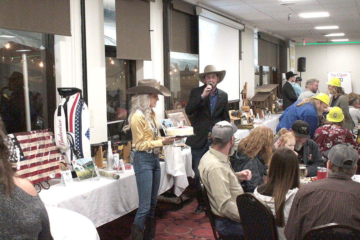 Auctioneer Tucker Cool, with the help of Miss Moses Lake Roundup Annabelle Booth, looks for bids on a dessert at the 2023 Youth Outdoors Unlimited banquet and auction. This year’s auction is March 2.