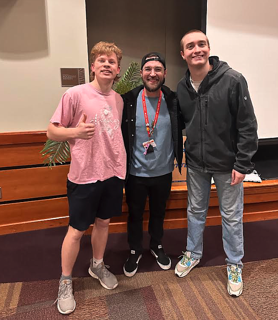 Interact Club of Coeur d'Alene member and Lake City High junior Rowen Lair, left, and Lake City senior and Interact Club President Luke Sharon, right, snap a photo with Kroc Center counselor Tyson Durbin during Thursday's Coping with Creativity mental health awareness event.
