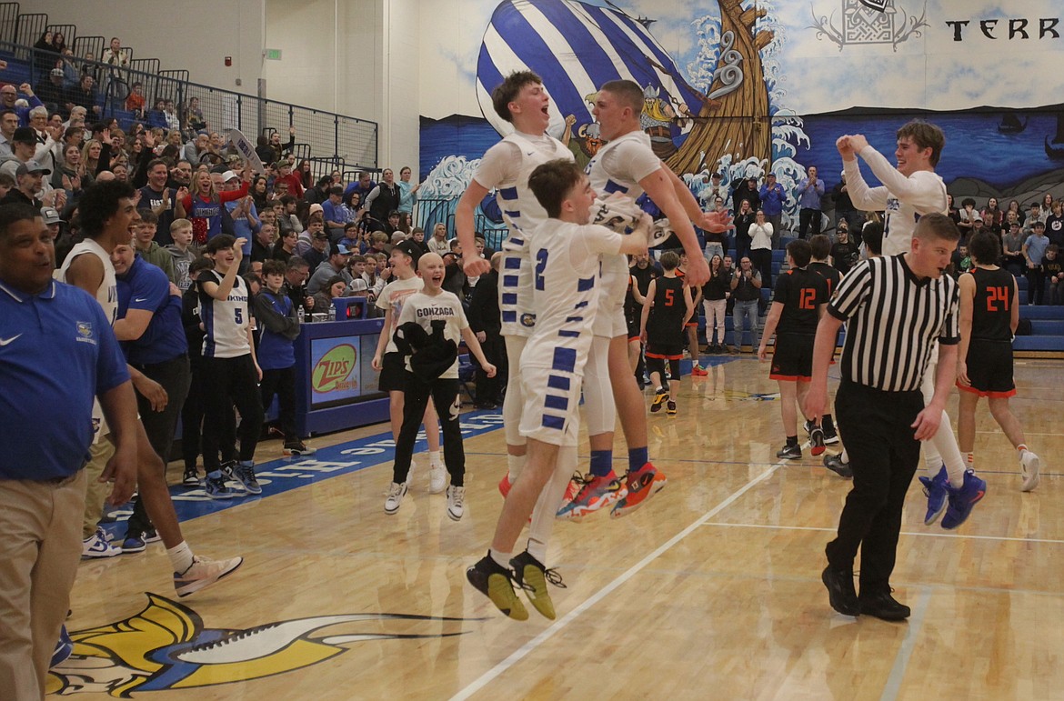 MARK NELKE/Press Coeur d'Alene players, coaches and fans celebrate after the Vikings won the 5A Region 1 boys basketball championship over Post Falls on Tuesday night at Viking Court.