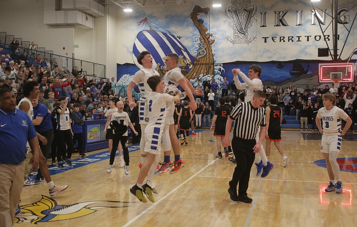 MARK NELKE/Press
Coeur d'Alene players, coaches and fans celebrate after the Vikings won the 5A Region 1 boys basketball championship over Post Falls on Tuesday night at Viking Court.