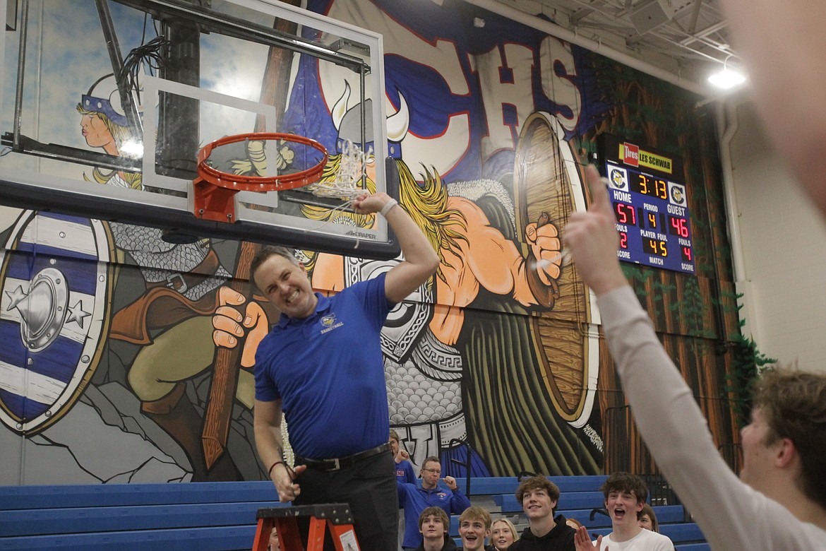 MARK NELKE/Press
Coeur d'Alene coach Jon Adams celebrates after cutting down the last piece of the net after the Vikings won their first 5A Region 1 championship since 2011 on Tuesday night at Viking Court.