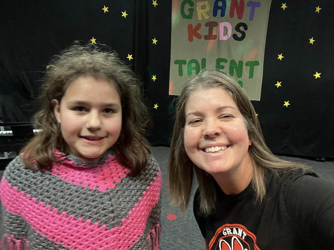 A Grant Elementary staff member poses with a student during the campus talent show.