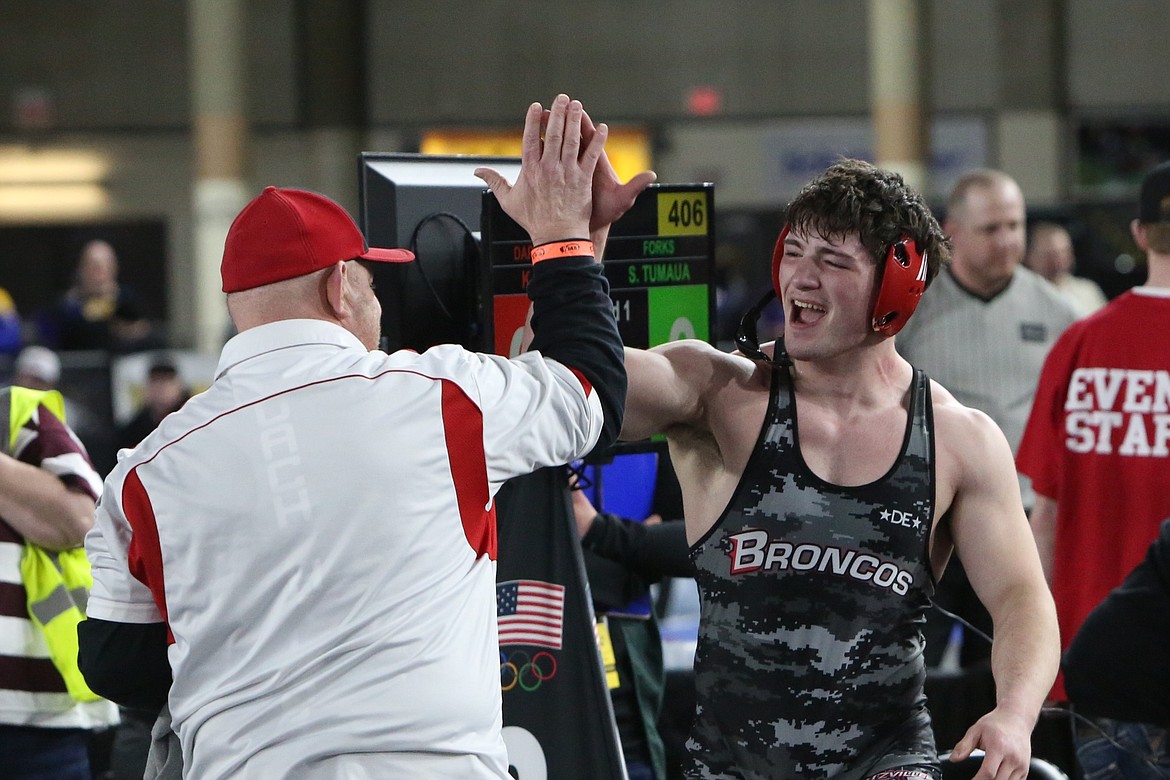 Lind-Ritzville/Sprague senior Gabe Smith, left, high-fives Bronco Head Coach Jason Hilzer, left, after winning a state championship in the 1B/2B 215-pound weight class at the Mat Classic in Tacoma.