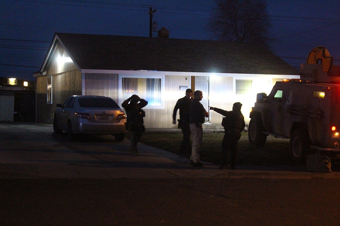 Law enforcement officers congregate outside a West Loop Drive home where a man briefly barricaded himself inside Tuesday night.