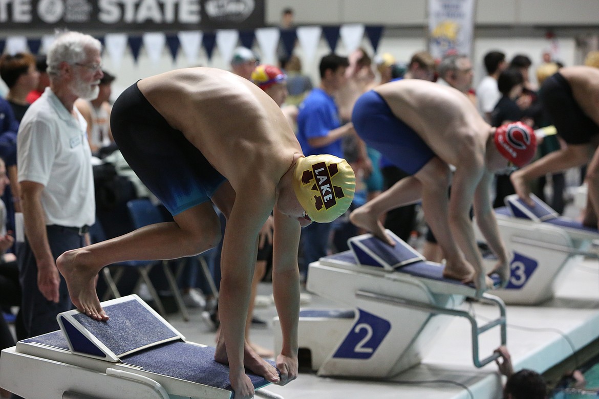 Moses Lake junior Dylan Moore, left, gets set on the starting platform ahead of the 200-yard individual medley at the King County Aquatic Center in Federal Way.