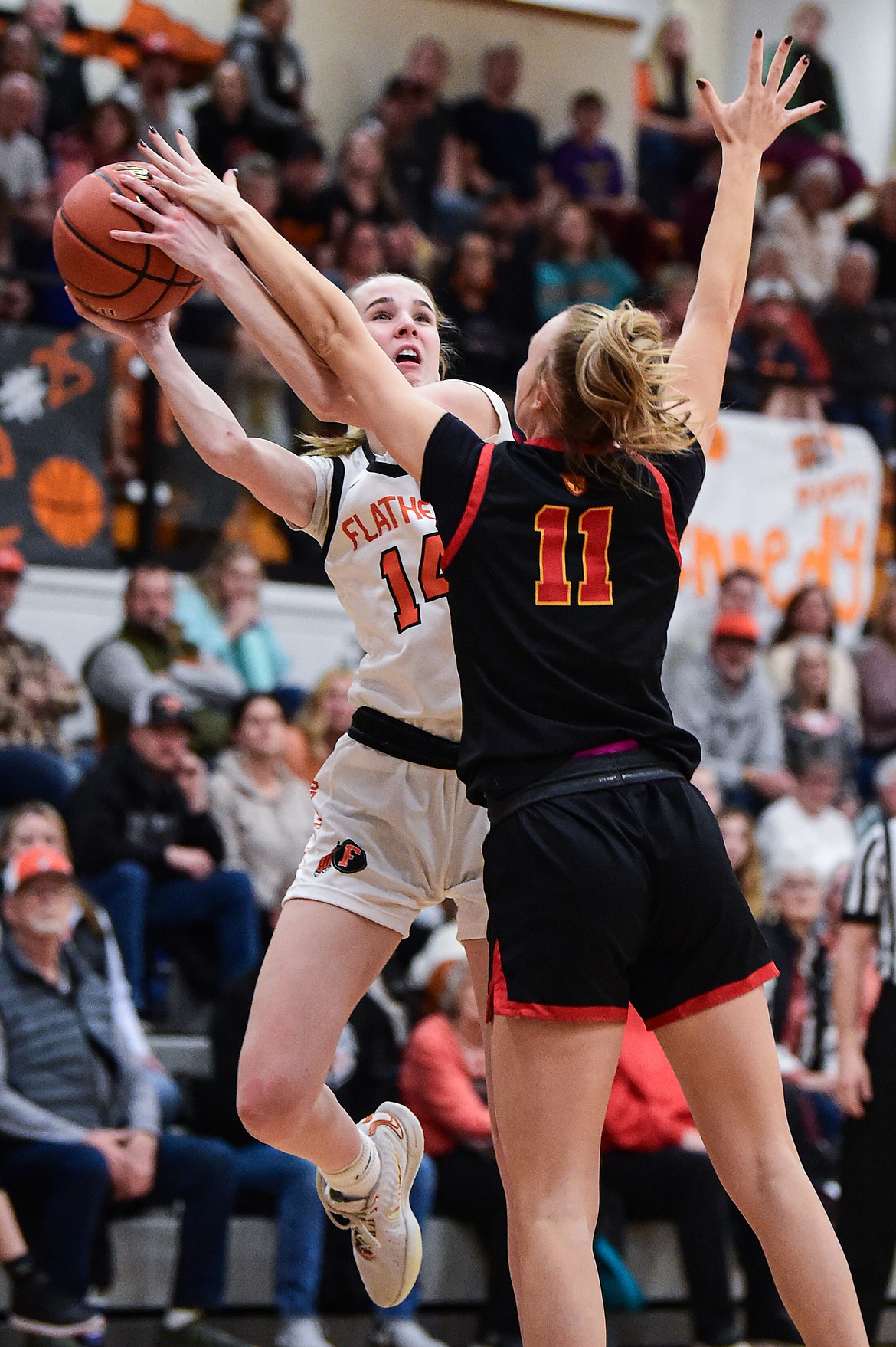 Flathead's Kennedy Moore (14) works for a shot against Missoula Hellgate's Alix Mund (11) at Flathead High School on Thursday, Feb. 22. (Casey Kreider/Daily Inter Lake)