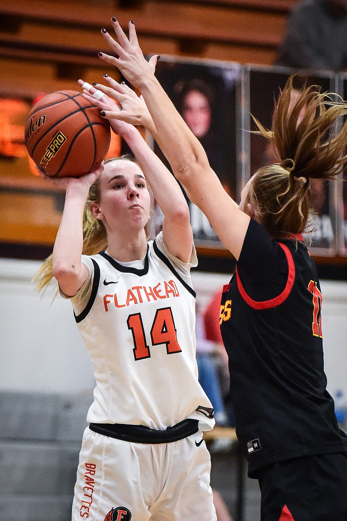 Flathead's Kennedy Moore (14) works for a shot against Missoula Hellgate's Alix Mund (11) in the second half at Flathead High School on Thursday, Feb. 22. (Casey Kreider/Daily Inter Lake)