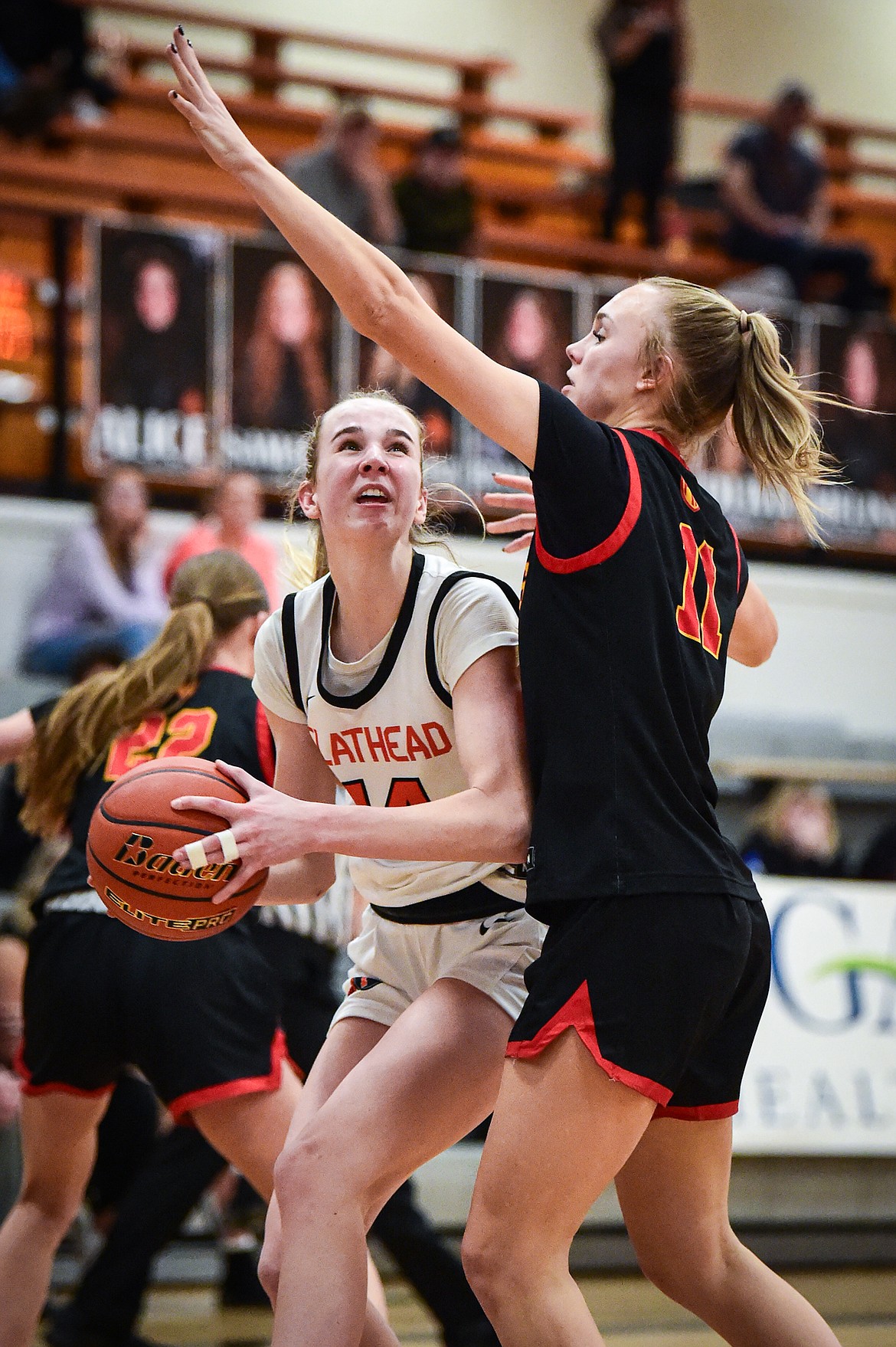 Flathead's Kennedy Moore (14) works for a shot against Missoula Hellgate's Alix Mund (11) in the second half at Flathead High School on Thursday, Feb. 22. (Casey Kreider/Daily Inter Lake)