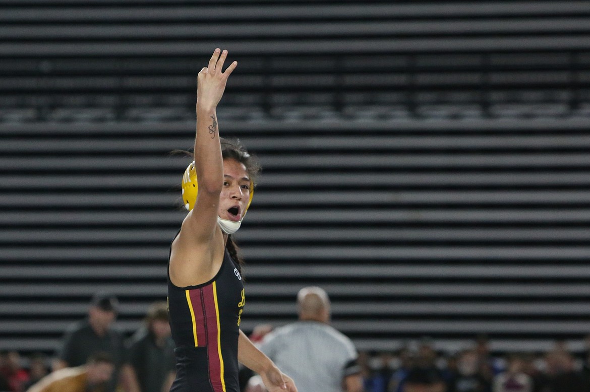 Moses Lake senior Ashley Naranjo holds up three fingers after winning a state title at the Mat Classic – one finger for each of her three state titles.