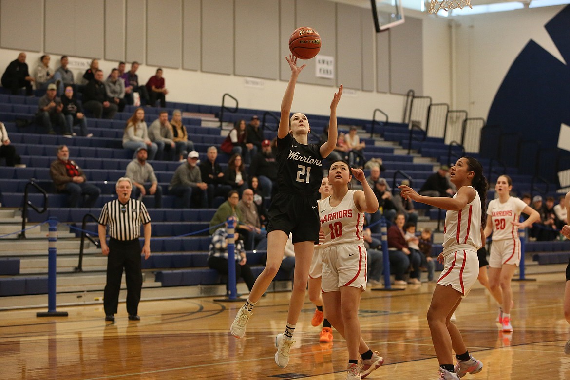 Almira/Coulee-Hartline senior Natalie Evers (21) attempts a shot under the rim in the first quarter against Crosspoint.