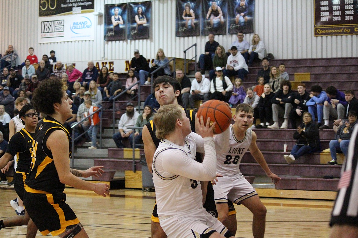 Jonah Robertson, in white, pulls up for the shot in Friday’s state 1B playoff game against Cusick.