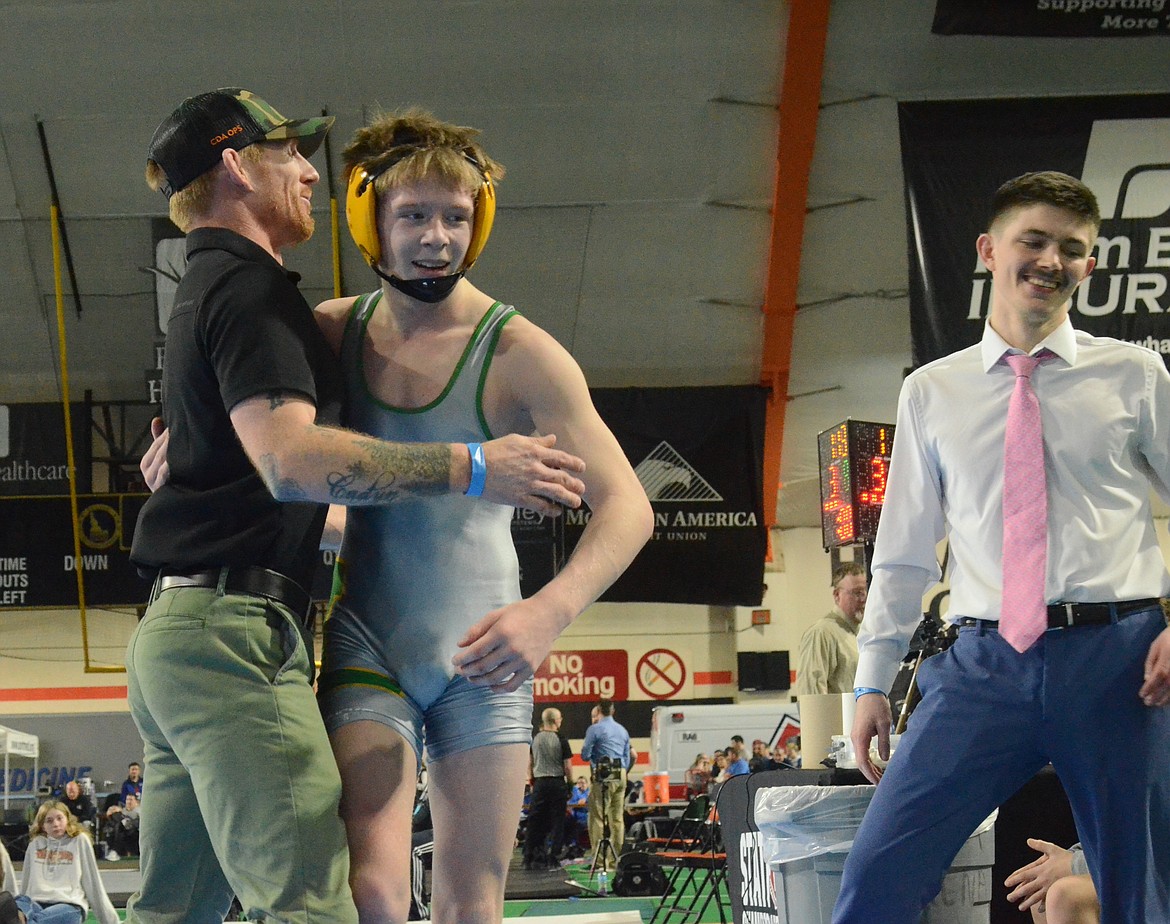 Photos by NORM, DAN and KELLY SEE
Lakeland freshman Carson Leonard celebrates after winning a state 4A 113-pound title with his dad, Clint, a three-time state champion at Lakeland, and Hawks coach Will Edelblute, right, at the state wrestling championships Saturday at the ICCU Dome in Pocatello.