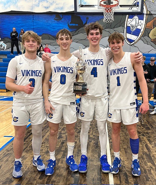 Courtesy photo
Coeur d'Alene High's four seniors — from left, Trey Nipp, Gunner Larson, Max Entzi and Logan Orchard — celebrate with the trophy after the Vikings won the 5A Region 1 boys basketball championship last week, qualifying for state for the first time since 2012.