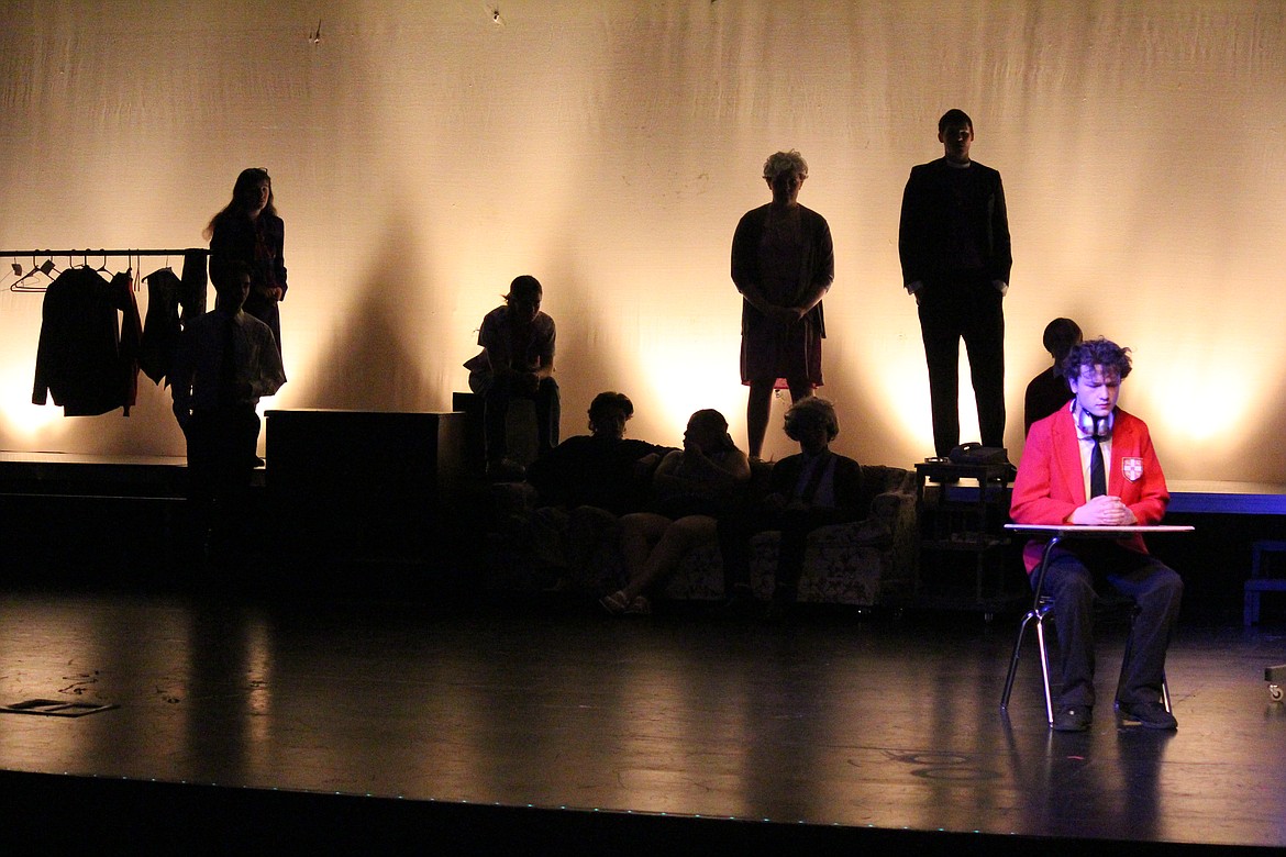 Christopher (Noah Carlile) sits in school, in front of the interested audience in the ensemble.