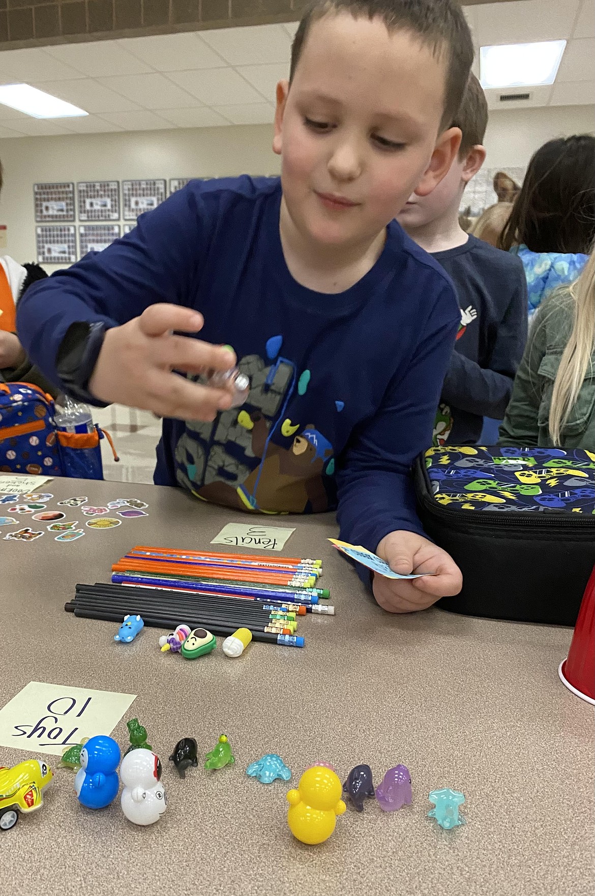 West Ridge Elementary first grader Mason Debrunner spends his Cougar Cash on animal toys.