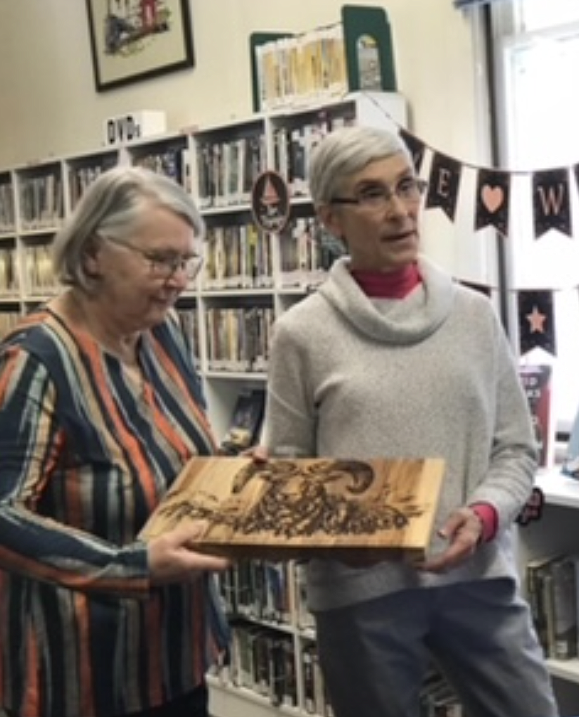 Guna Chaberek, Mineral County librarian, presents Connie Acker with a beautiful bighorn sheep plaque as a sincere thank you for all her years as the Alberton branch librarian at her retirement celebration Feb. 15. 

“Connie innovated on the solid foundation created by the librarians before her,” said Chaberek. “She arranged several very successful wine-tasting fundraisers and increased the usage of the branch to a great degree.  The library board has commended her on multiple occasions, and we are all very grateful for her dedicated service to the branch and patrons.”