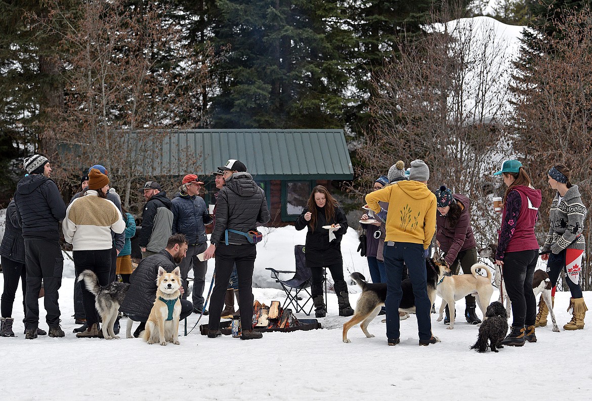 Participants gather around the fire at the Flathead Classic dog sled races at the Dog Creek Lodge in Olney. (Julie Engler/Whitefish Pilot)