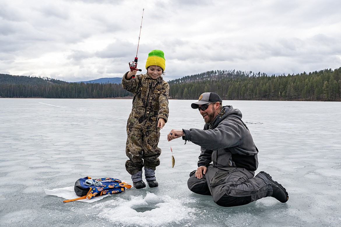 GGES fourth grader Jameson Solorio and Hooked on Fishing's Kirk Rasmussen celebrate Solorio’s catch on Murphy Lake Thursday, Feb. 22. (Avery Howe photo)