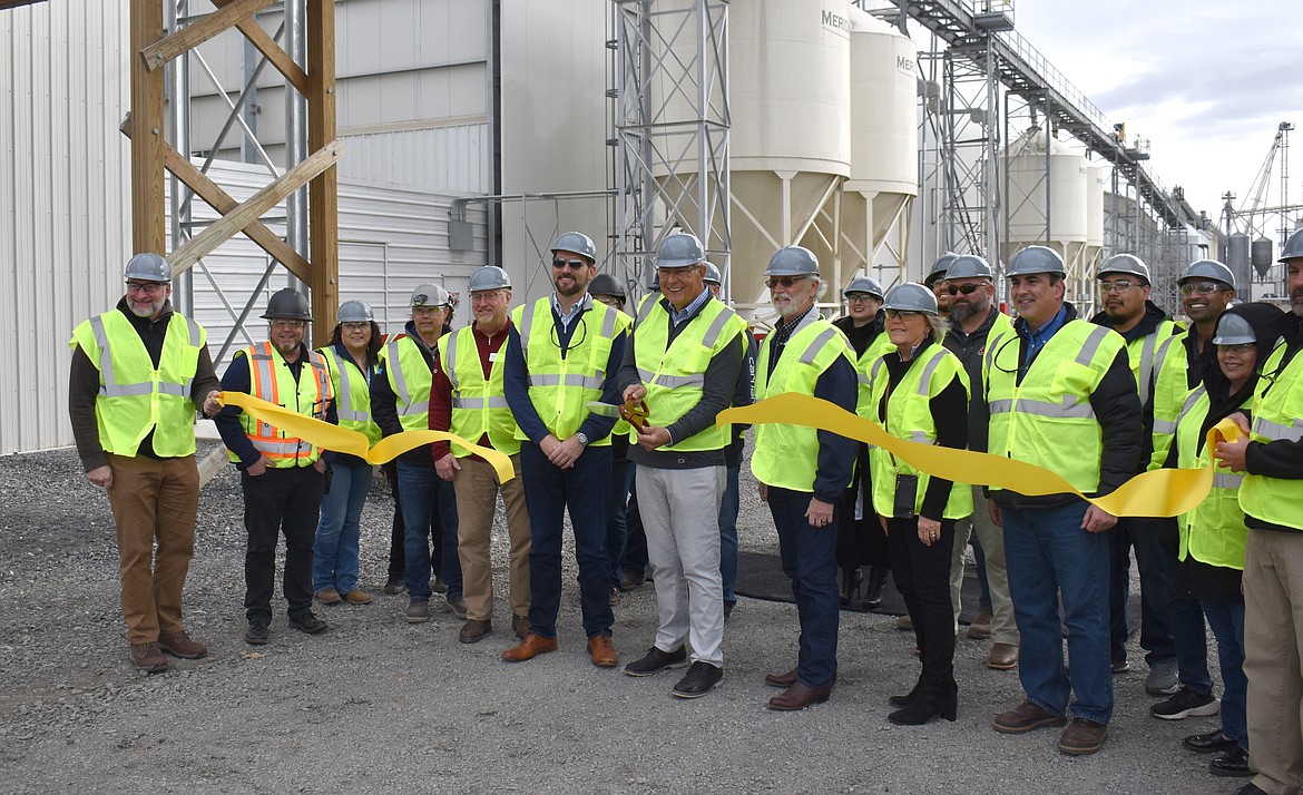 Jim Dean, CEO of Versova, parent company of Willamette Egg Farms, cuts the ceremonial ribbon at the company’s expanding Moses Lake facility,  flanked by CFO Matthew Dean, left, and Rep. Dan Newhouse, R-Washington, right, and surrounded by Willamette Egg Farms personnel and Moses Lake Chamber of Commerce members.