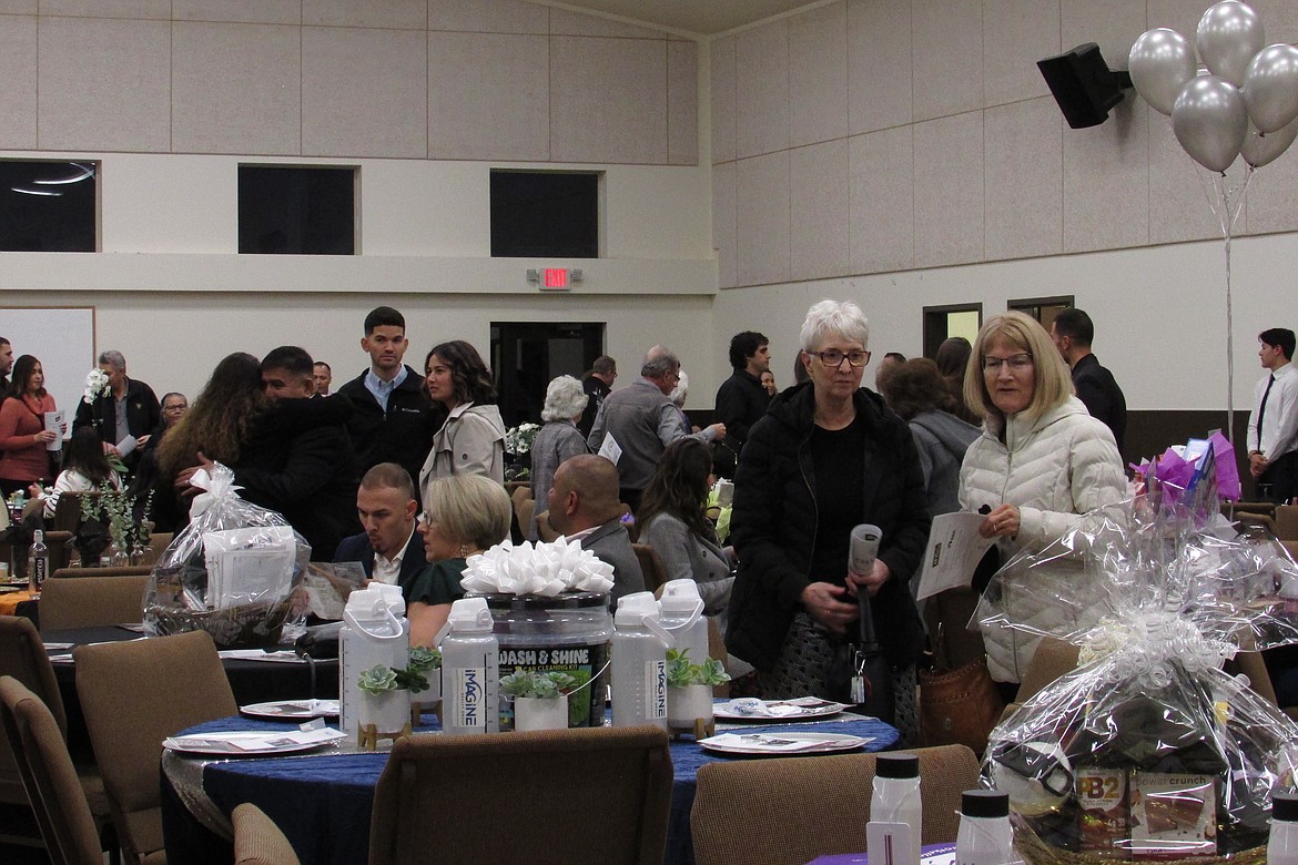 Guests of Friday evening’s Greater Othello Chamber of Commerce Awards Banquet look at silent auction items open for bidding prior to the dinner party and events.