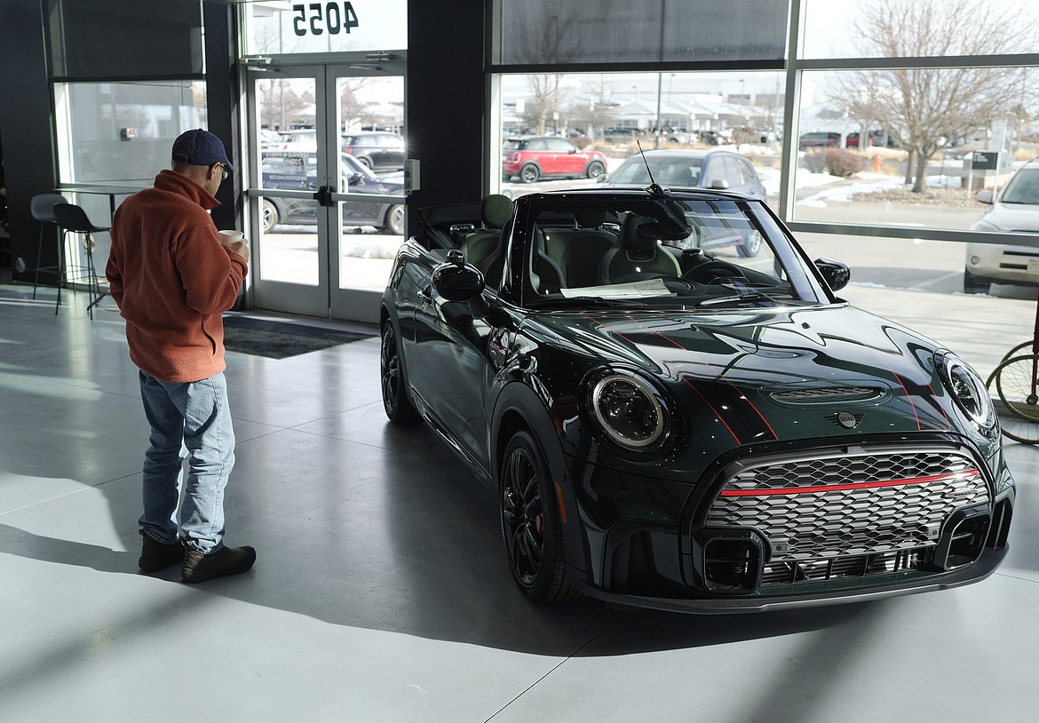 A man looks at a 2024 Cooper S John Cooper Works convertible at a Mini dealership on Nov. 30, 2023, in Loveland, Colo. Automobile prices, which had been fueling inflation in the U.S., are starting to drop, helping to slow overall consumer price increases and giving buyers hope of getting a deal. (AP Photo/David Zalubowski, File)
