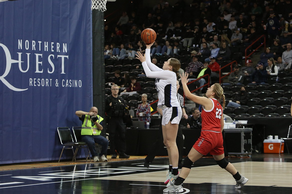 Warden freshman Makenna Klitzke, in white, scores a basket in the first quarter against Davenport.