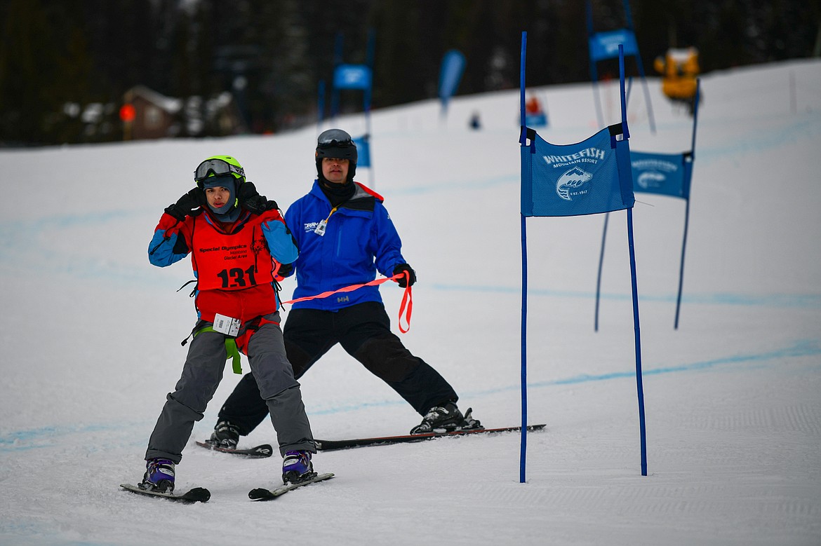 Cole Garvey, with the Eureka Magic team, weaves between gates with Dream Adaptive coach Adrian Miller in the Alpine Slalom event during the Special Olympics Montana Glacier Area Winter Games at Whitefish Mountain Resort on Thursday, Feb. 29. (Casey Kreider/Daily Inter Lake)